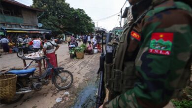 A TNLA fighter on guard duty in a market in Kyaukme in July 2024 (Photo: AFP)
