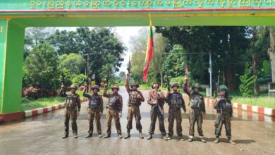 A group of junta troops pose for a photo at an entrance to Kyuakme Town, Shan State on October 1, 2025.