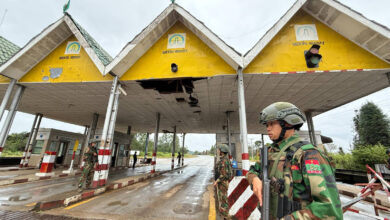 A Ta'ang National Liberation Army (TNLA) soldier stands at the entrance of Kutkai Town, Shan State, on the Kutkai–Muse Road, in October 2025 (Photo: Myanmar Now)