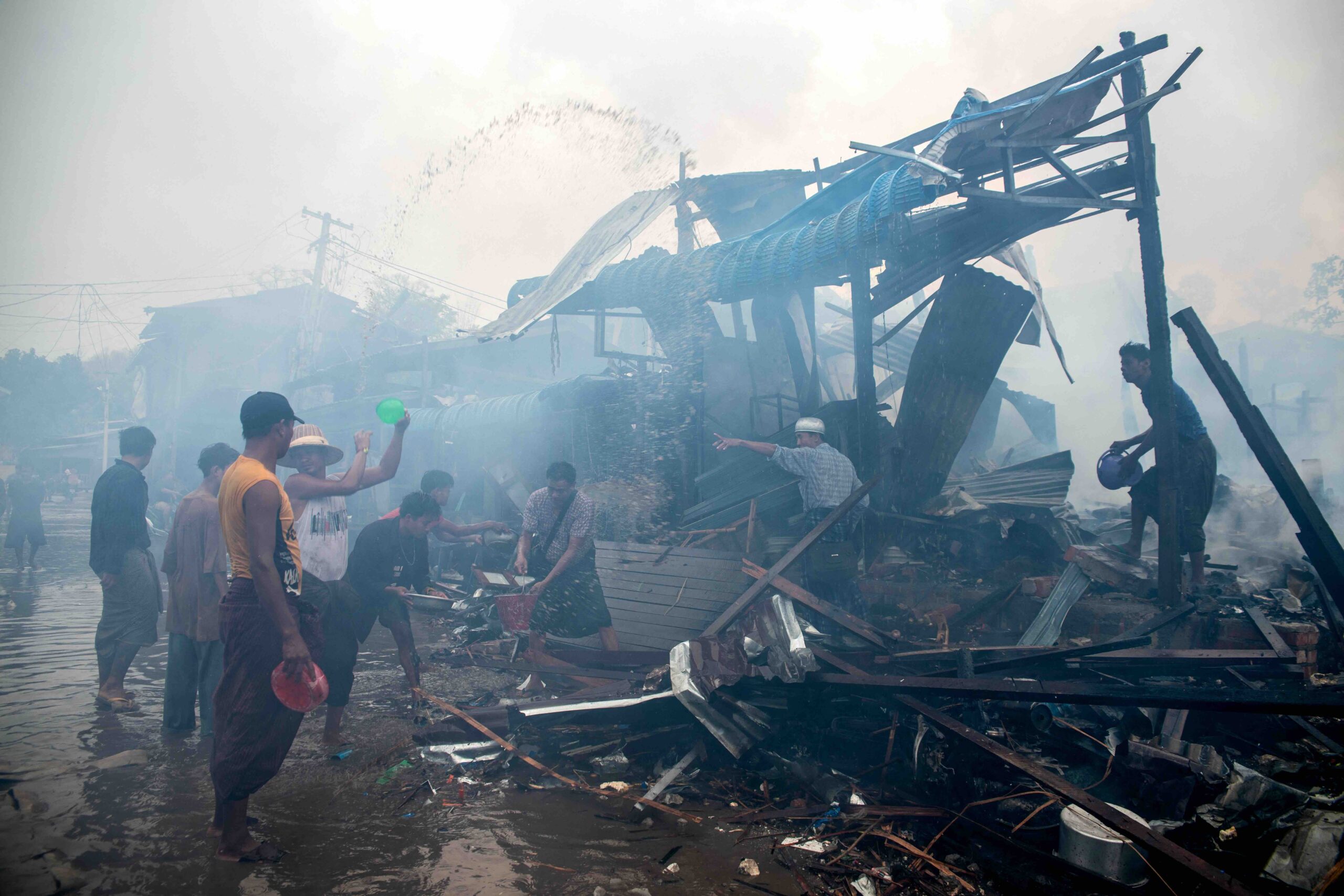 People extinguish a fire in a building that was destroyed in a bombardment carried out by Myanmar's military in Thabeikkyin Township in Mandalay Region on April 19, 2025. (Photo: AFP)