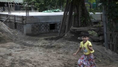 This photo taken on August 15, 2025 shows a child playing next to a concrete bunker used as a classroom to protect against airstrikes at a village in the Sagaing region.