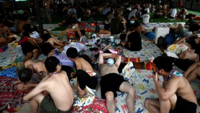 In this photo taken on February 23, 2025 alleged scam centre workers and victims rest during a crackdown operation by the Karen Border Guard Force (BGF) on illicit activity, at the border checkpoint with Thailand in Myanmar's eastern Myawaddy township. (Photo: AFP)