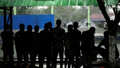 In this photo taken on February 23, 2025 alleged scam centre workers and victims stand together during a crackdown operation by the Karen Border Guard Force (BGF) on illicit activity, at the border checkpoint with Thailand in Myanmar's eastern Myawaddy township. (Photo: AFP)