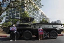 Anti-coup protesters hold up signs in front of the Central Bank of Myanmar’s Yangon office in February 2021 (Photo: Myanmar Now)