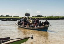 Displaced residents cross a river to safety after fleeing fighting in Bhamo in December 2024 (Photo: AFP)