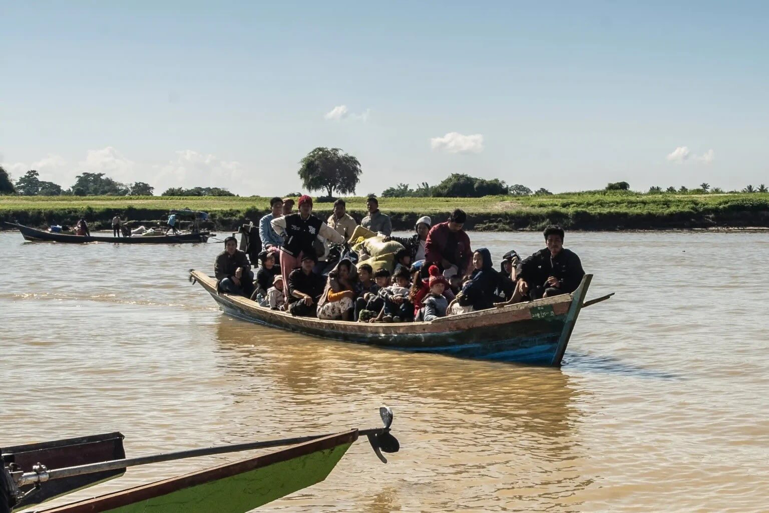 Displaced residents cross a river to safety after fleeing fighting in Bhamo in December 2024 (Photo: AFP)