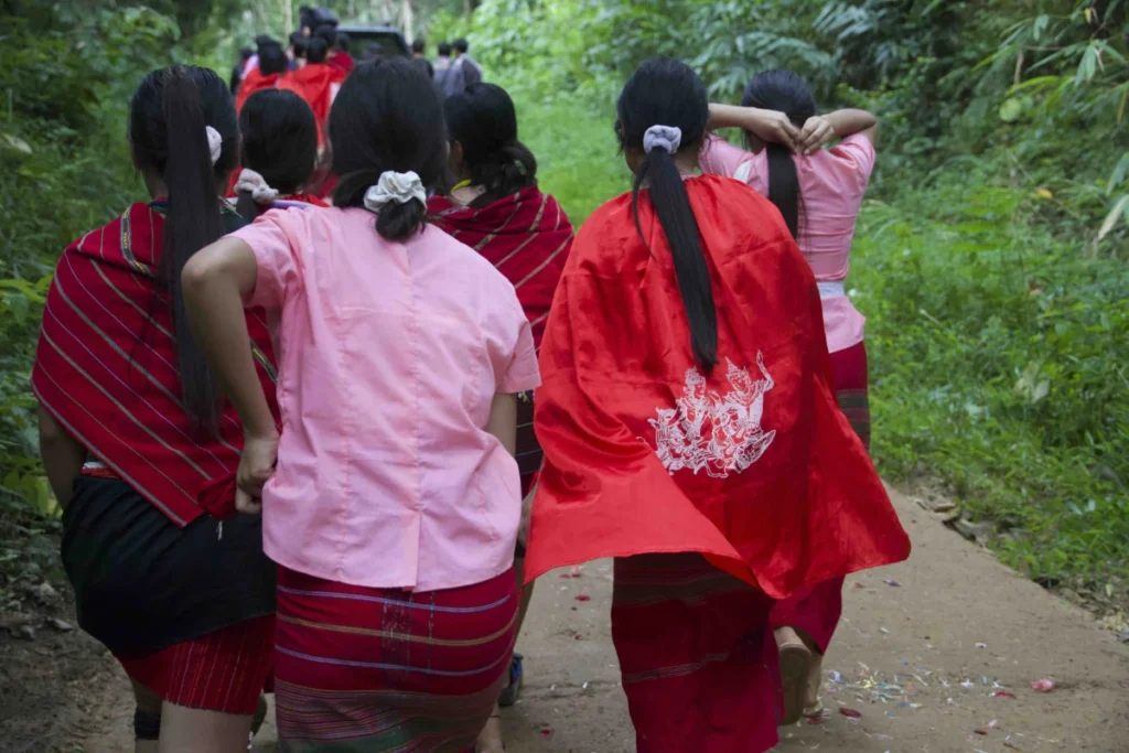  Karenni women in brightly coloured traditional dress follow the funeral procession (Photo: Saw Reh / Myanmar Now) 