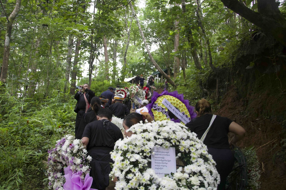  Mourners with wreaths climb a path inside Karenni State (Photo: Saw Reh / Myanmar Now) 