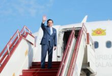 Min Aung Haling waves as he boards a plane to depart for a two-day visit to Malaysia on October 7 (Photo: Myanmar junta’s Presidential Press and Information Bureau / AFP)
