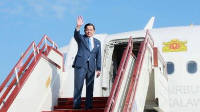 Min Aung Haling waves as he boards a plane to depart for a two-day visit to Malaysia on October 7 (Photo: Myanmar junta’s Presidential Press and Information Bureau / AFP)