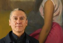 Kim Aris stands in front of a painting of his mother Aung San Suu Kyi in his London home (Photo: Supplied)