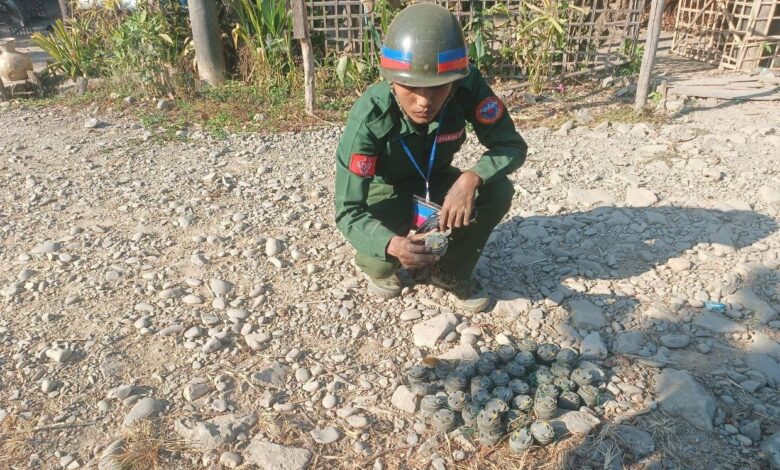 တောင်ကုတ်မြို့ ခမရ (၅၄၄) တပ်ရင်းအနီး မတ်လ ၁၀ ရက်နေ့က တူးဖော်ရှင်းလင်းခဲ့သော မြေမြှုပ်မိုင်းတချို့နှင့် အတူတွေ့ရသော AA တပ်ဖွဲ့ဝင်တစ်ဦး။ (ဓာတ်ပုံ -APM)