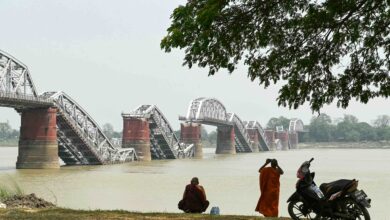 ပြင်းထန်သော ငလျင်ကြောင့် ဧရာဝတီမြစ်အတွင်း ပြိုကျသွားသော စစ်ကိုင်းတံတား (အင်းဝ) အနီး တွေ့ရသော သံဃာ ၂ ဦး။ (ဓာတ်ပုံ-AFP)