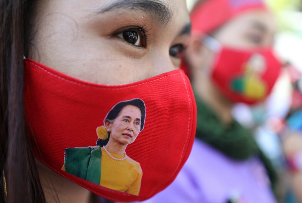 ၂၀၂၃ ဒီဇင်ဘာ ၁၇ ရက်နေ့က ဘန်ကောက်မြို့ လှုပ်ရှားမှုတစ်ခုတွင် ဒေါ်အောင်ဆန်းစုကြည်ပုံပါ နှာခေါင်းစည်း တပ်ဆင်ထားသူတစ်ဦး။  (ဓာတ်ပုံ - EPA)
