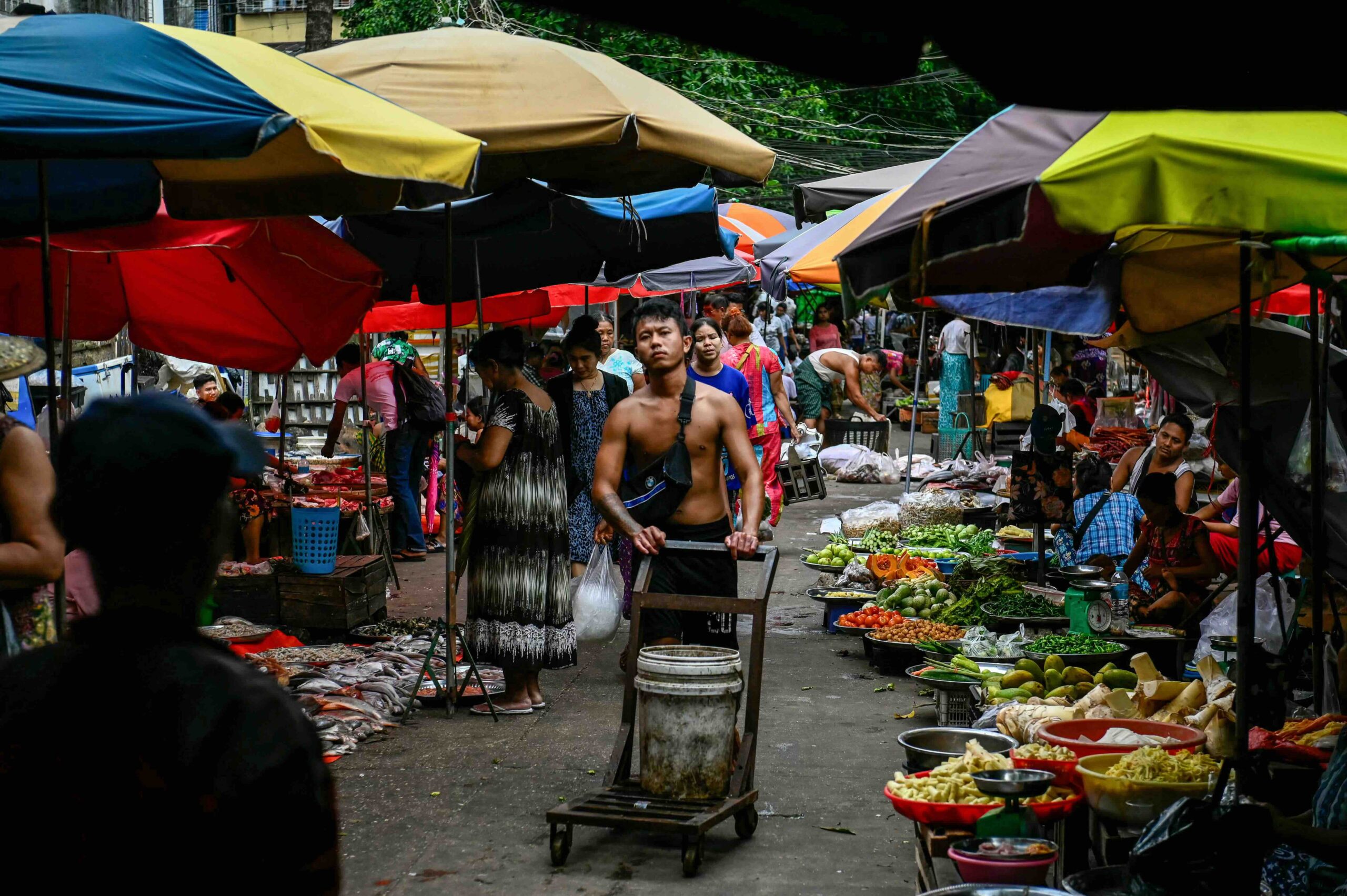 ရန်ကုန်မြို့ လမ်းဘေးဈေးတစ်ခုအတွင်း လူအများသွားလာနေကြသည်ကို ဩဂုတ်လ ၄ ရက်နေ့က တွေ့ရစဉ်။ (ဓာတ်ပုံ-AFP)