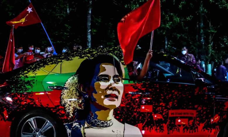 ၂၀၂၀ ခုနှစ် နိုဝင်ဘာလ ၈ ရက်ကကျင်းပသည့် ရွေးကောက်ပွဲတွင် မဲရုံများပိတ်ပြီးနောက် မဲရလဒ်များ ရေတွက်နေချိန် NLD ပါတီကို ထောက်ခံသူများက မန္တလေးမြို့ရှိ ပါတီရုံးရှေ့တွင် အလံများ ဝှေ့ယမ်းအောင်ပွဲခံနေပုံ။ ဓာတ်ပုံ − AFP