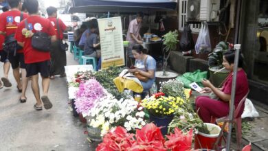 ရန်ကုန်မြို့ ဈေးတစ်နေရာအတွင်း ရွေးကောက်ပွဲ လက်ကမ်းစာစောင် ဖြန့်ဝေနေသူ အချို့ကို တွေ့ရပုံ (ဓာတ်ပုံ − EPA)