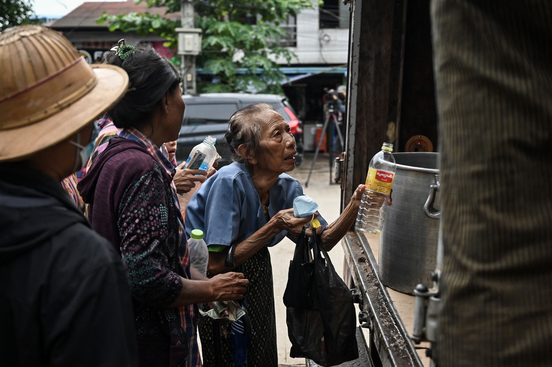 အရည်အသွေးမမီ စားအုန်းဆီ ရေသန့်တစ်ဘူးစာရရန် တန်းစီဝယ်ယူနေသည့် ရန်ကုန်မြို့မှ အမယ်အိုတစ်ဦးကို ၂၀၂၂ ခုနှစ် ဩဂုတ်လအတွင်း တွေ့ရစဉ်။