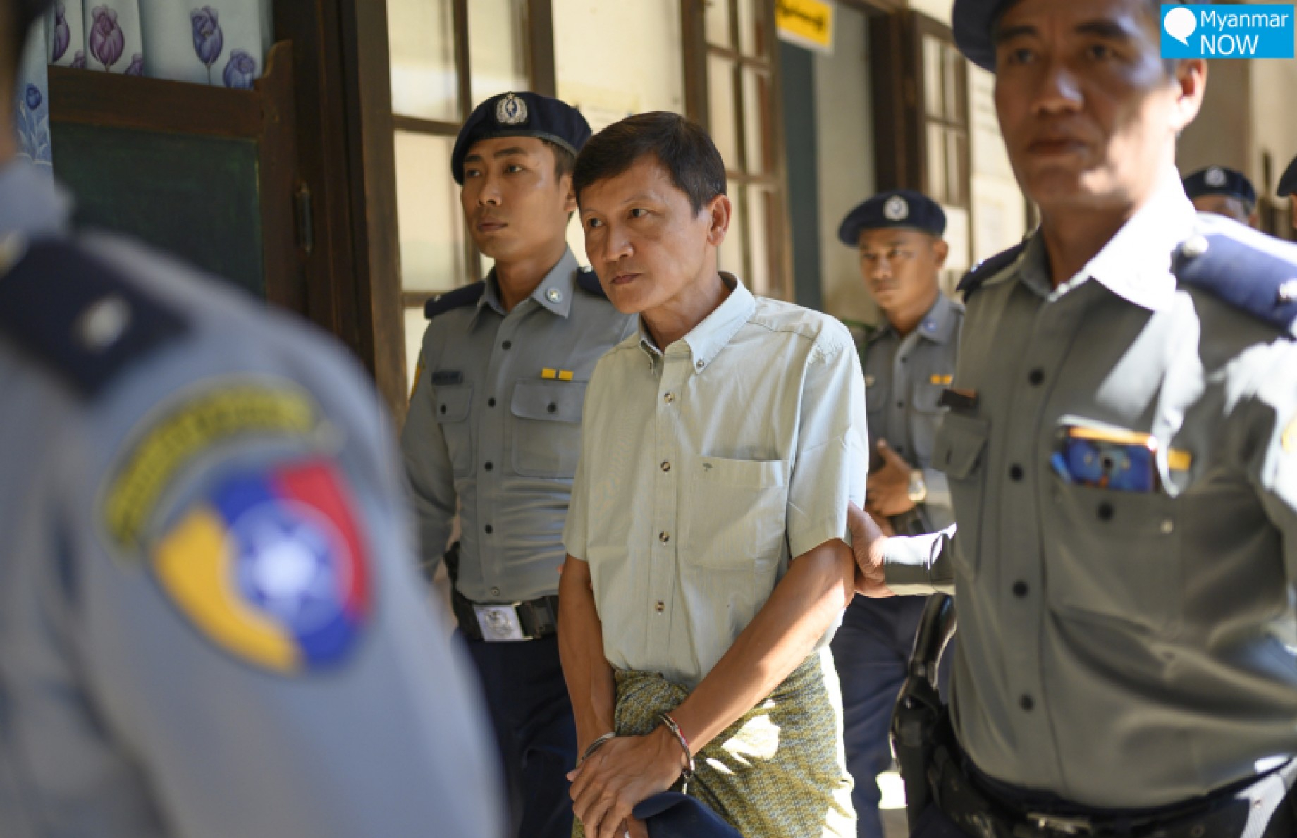 -အကျဉ်းကျနေသည့် စီးပွားရေးသမား ဦးစိုးထွန်းရှိန် ကို ၂၀၁၉ ခုနှစ် နိုဝင်ဘာလက တရားရုံးထုတ်လာချိန်တွင် တွေ့ရစဉ်။ (Myanmar Now)