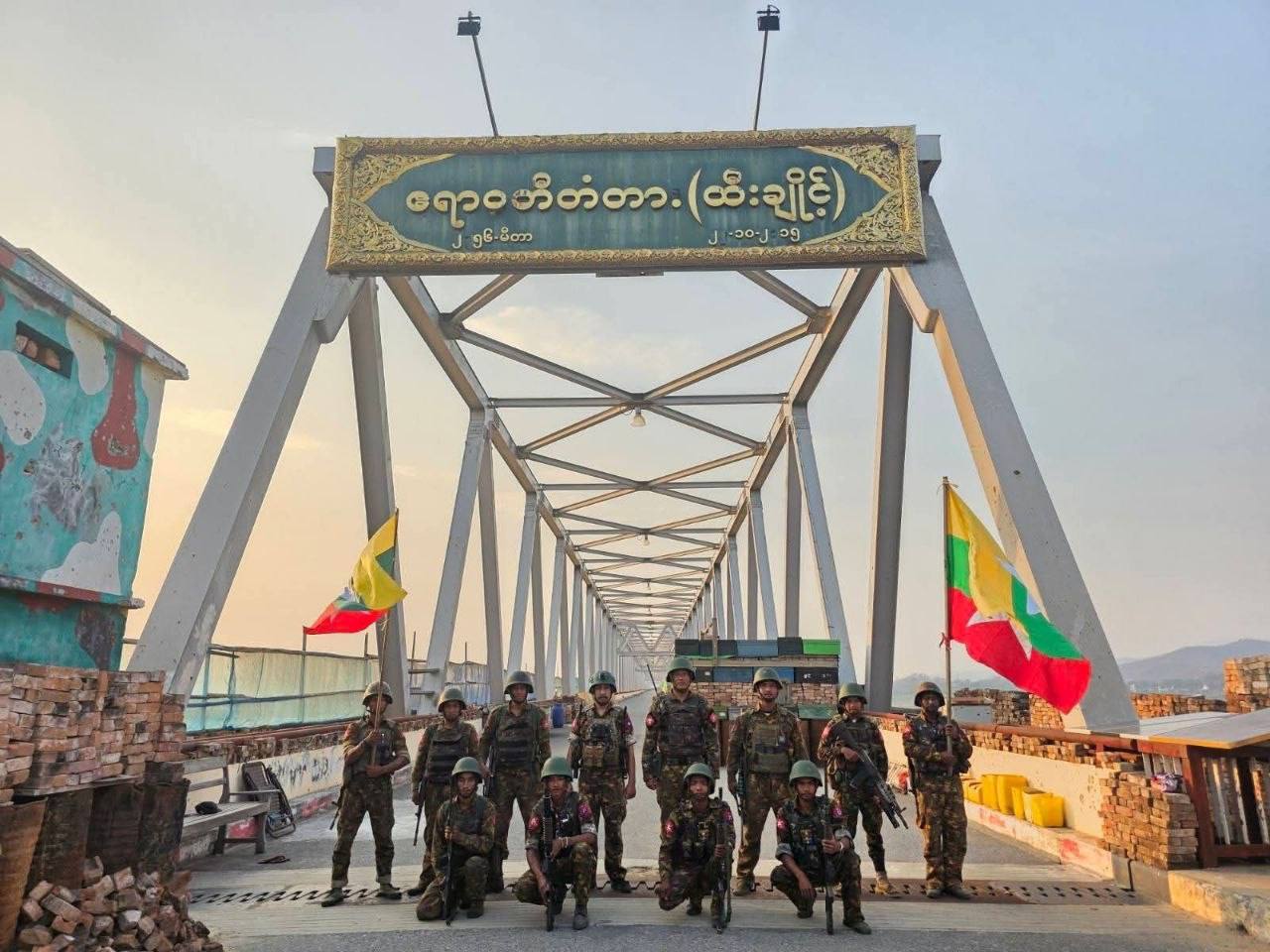 -စစ်တပ်ဝါဒဖြန့်သူများက မတ်လ ၂၆ ရက်နေ့က ဖော်ပြထားသော ထီးချိုင့်မြို့အဝင် ဧရာဝတီ မြစ်ကူးတံတားပေါ်တွင် တွေ့ရသော စစ်ကော်မရှင်တပ်သားများ။