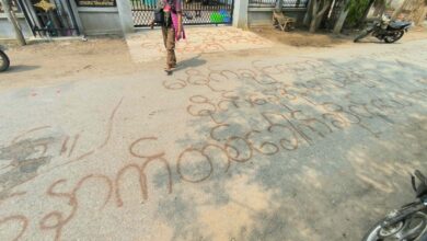 ဧပြီလအတွင်း စစ်သားများ ဝင်ရောက်ခဲ့သော ယင်းမာပင်နယ် ကျေးရွာတစ်ရွာတွင် ရေးသားခဲ့သော စာများအနီး တွေ့ရသည့် တော်လှန်ရေးတပ်ဖွဲ့ဝင်တစ်ဦး။။ (ဓာတ်ပုံ- ပေးပို့)