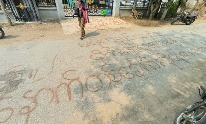 ဧပြီလအတွင်း စစ်သားများ ဝင်ရောက်ခဲ့သော ယင်းမာပင်နယ် ကျေးရွာတစ်ရွာတွင် ရေးသားခဲ့သော စာများအနီး တွေ့ရသည့် တော်လှန်ရေးတပ်ဖွဲ့ဝင်တစ်ဦး။။ (ဓာတ်ပုံ- ပေးပို့)