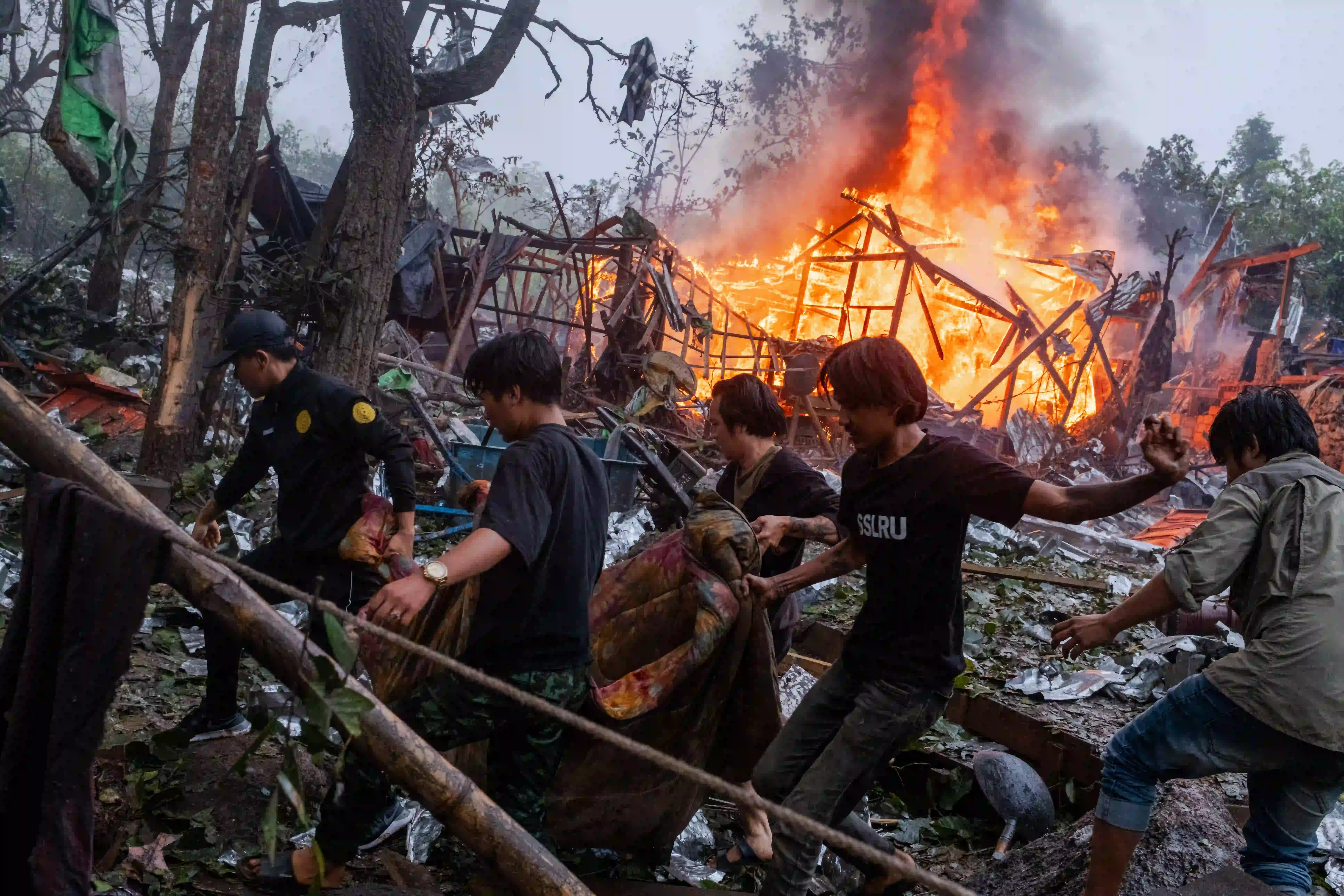 ဒီးမော့ဆိုမြို့နယ် အနောက်ဘက်တွင် စစ်တပ်၏ လေကြောင်းတိုက်ခိုက်မှုကြောင့် သေဆုံးသူ၏ ရုပ်အလောင်းကို ဒေသခံများနှင့် တော်လှန်ရေးအဖွဲ့ဝင်အချို့ သယ်ဆောင်နေကြသည်ကို တွေ့ရစဉ်။ (ဓာတ်ပုံ- Aung Kyaw Htet )