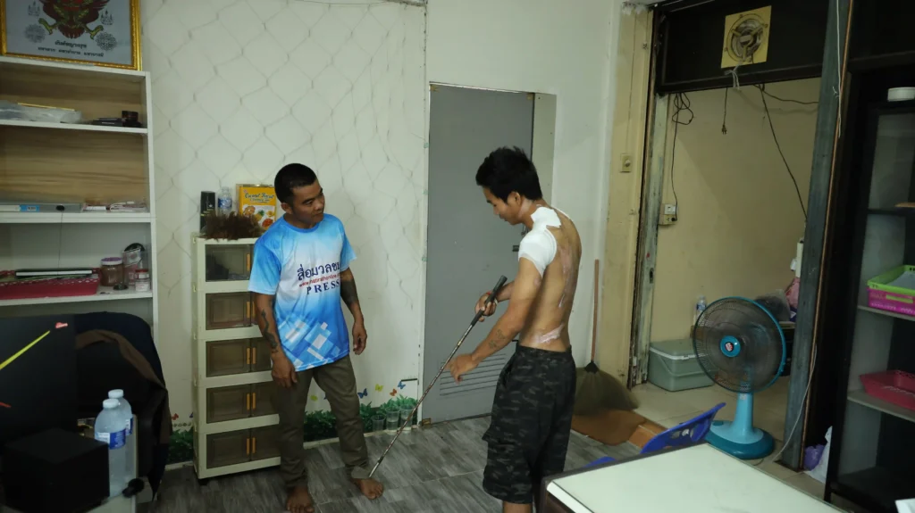ဂေါက်တံဖြင့် ရိုက်နှက်နှိပ်စက်ပုံကို ပြန်လည်ပြောပြနေသည့် ကိုသားသား။ (ဓာတ်ပုံ- Myanmar Now)