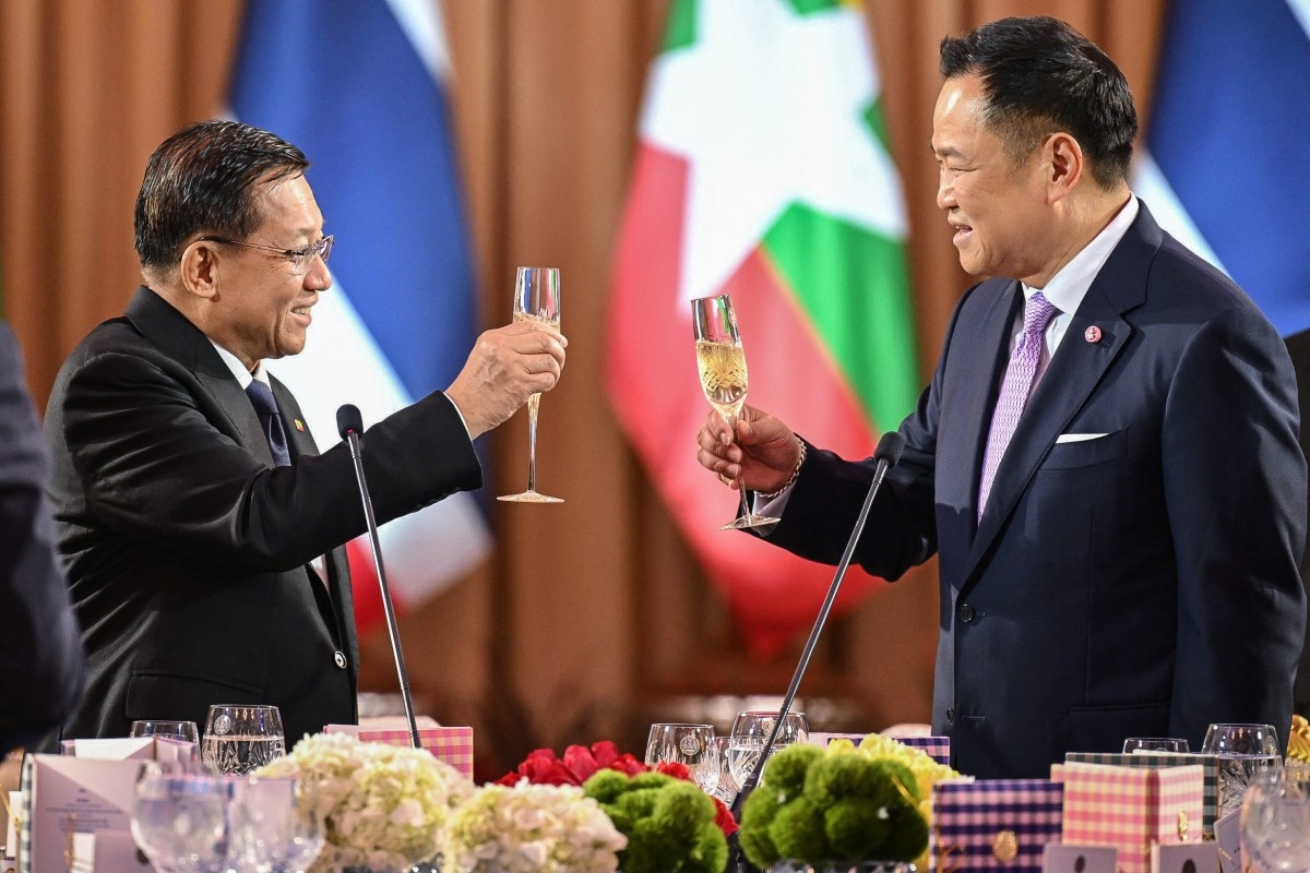 ဘန်ကောက်မြို့ အစိုးရအိမ်တော်၌ ဩဂုတ်လ ၆ ရက်က ကျင်းပသည့် ဂုဏ်ပြုညစာစားပွဲ၌ မြန်မာစစ်ခေါင်းဆောင် ဦးမင်းအောင်လှိုင်နှင့် ထိုင်းဝန်ကြီးချုပ် အနုတင်ချန်ဝီရကွန်းတို့ ဂုဏ်ပြုအရက်သောက်သုံးနေစဉ်။ 
