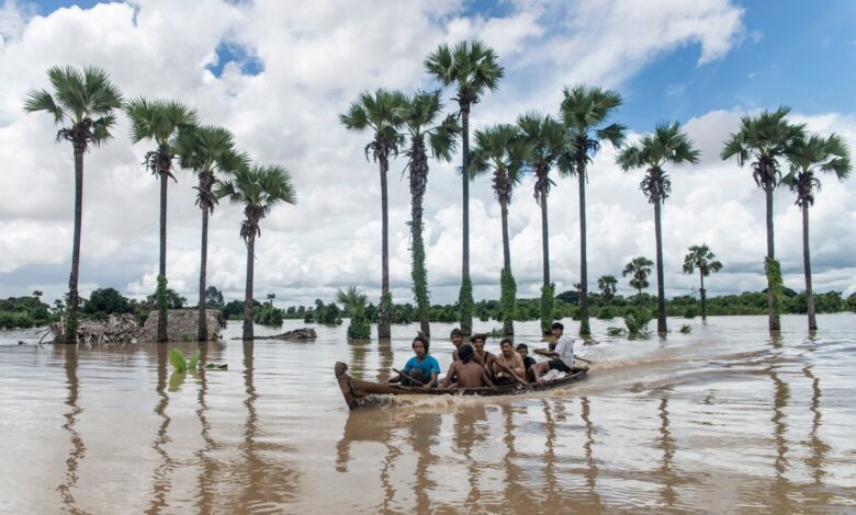 စစ်ကိုင်းတိုင်း ဝက်လက်မြို့နယ်တွင် မူးမြစ်ရေမြင့်တက်မှုကြောင့် ရေကြီးနေသည့်နေရာသို့ လှေဖြင့် သွားလာနေကြသည့် ဒေသခံများကို သြဂုတ်လ ၁၀ ရက်က တွေ့ရစဉ်။ (ဓာတ်ပုံ - AFP)