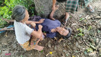 ဆွဲလွဲအိုရွာ တိုက်ခိုက်မှုတွင် ဗုံးစထိမှန် ဒဏ်ရာရရှိသူတစ်ဦး သစ်ပင်အောက်တွင် လဲလျောင်းနေသည်ကို ဩဂုတ်လ ၂၁ ရက်က တွေ့ရစဉ်။ (ဓာတ်ပုံ- ပေးပို့)