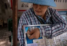 ဘန်ကောက်မြို့တွင် တွေ့ရသော ထိုင်းထီလက်မှတ် လှည့်လည်ရောင်းချသူတဦး။ (ဓာတ်ပုံ- AFP)