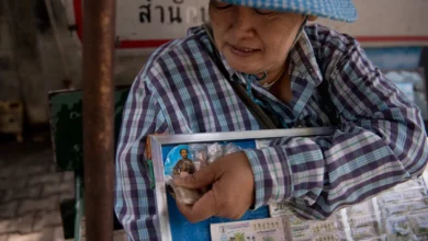 ဘန်ကောက်မြို့တွင် တွေ့ရသော ထိုင်းထီလက်မှတ် လှည့်လည်ရောင်းချသူတဦး။ (ဓာတ်ပုံ- AFP)
