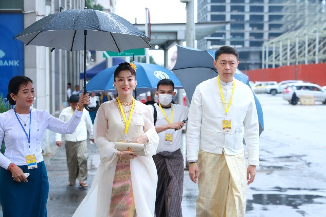 စစ်အုပ်စုနှင့်ဆက်နွှယ်မှုရှိသည့် ခရိုနီလက်သစ် ဦးနိုင်ဖြိုးကျော်နှင့် ဇနီးဖြစ်သူ သရုပ်ဆောင် ဝတ်မှုံရွှေရည်တို့ကို ရန်ကုန်မြို့ ဝဇီရာရုံရှင်ရုံအဆင့်မြင့်တင်ဖွင့်လှစ်ပွဲတွင် တွေ့ရစဉ်။ (ဓာတ်ပုံ- စစ်တပ်ဝါဒဖြန့်မီဒီယာ) 