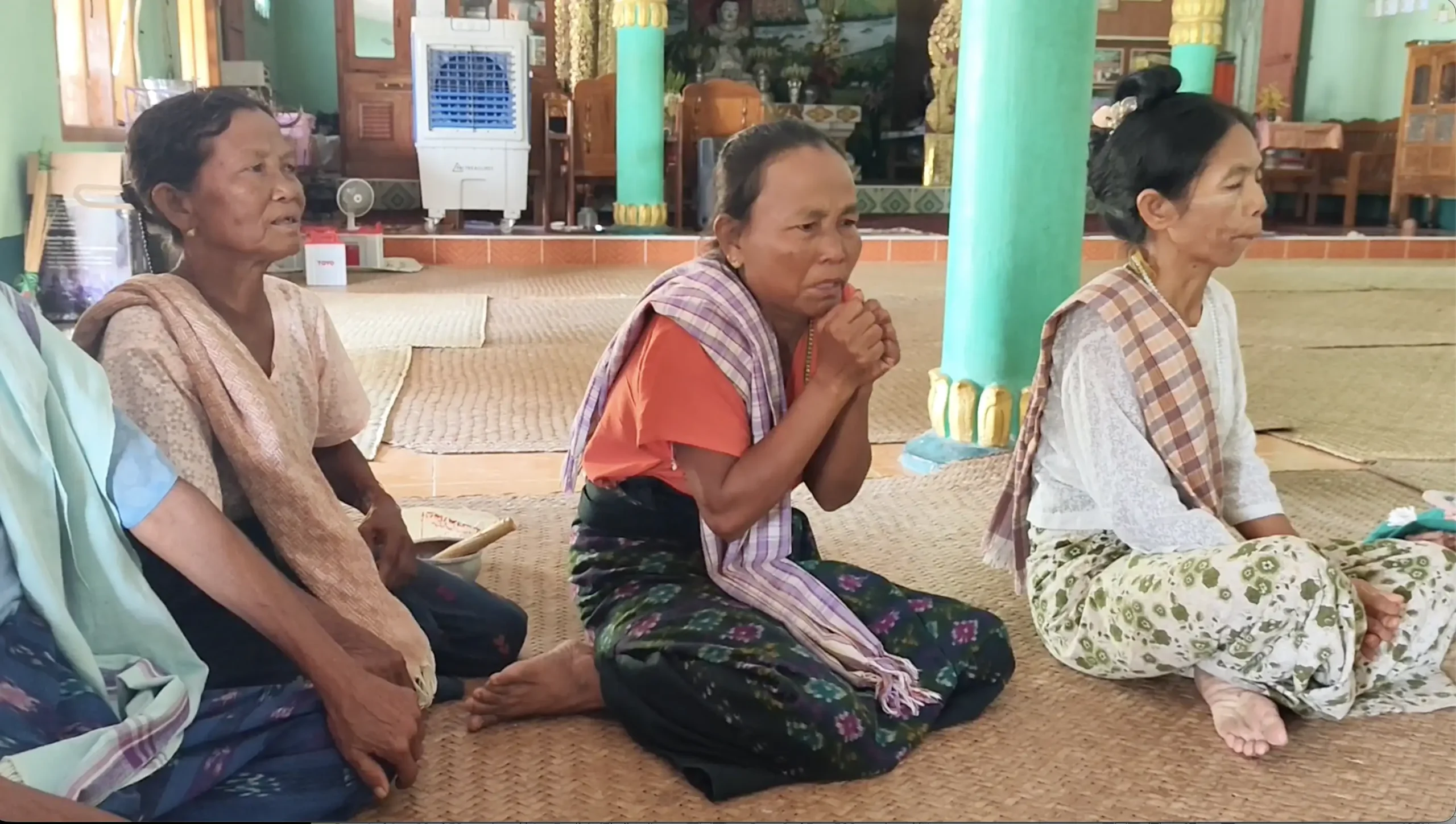 လေယာဉ်ဗုံးကြဲခြင်းကြောင့် ဘေးလွတ်ရာတွင် ပုန်းနေရပုံကို ငိုယိုပြောပြနေသည့် ဥပုသ်သည် တဦး။ ဓာတ်ပုံ- တင်စိုး(အညာမြေ)